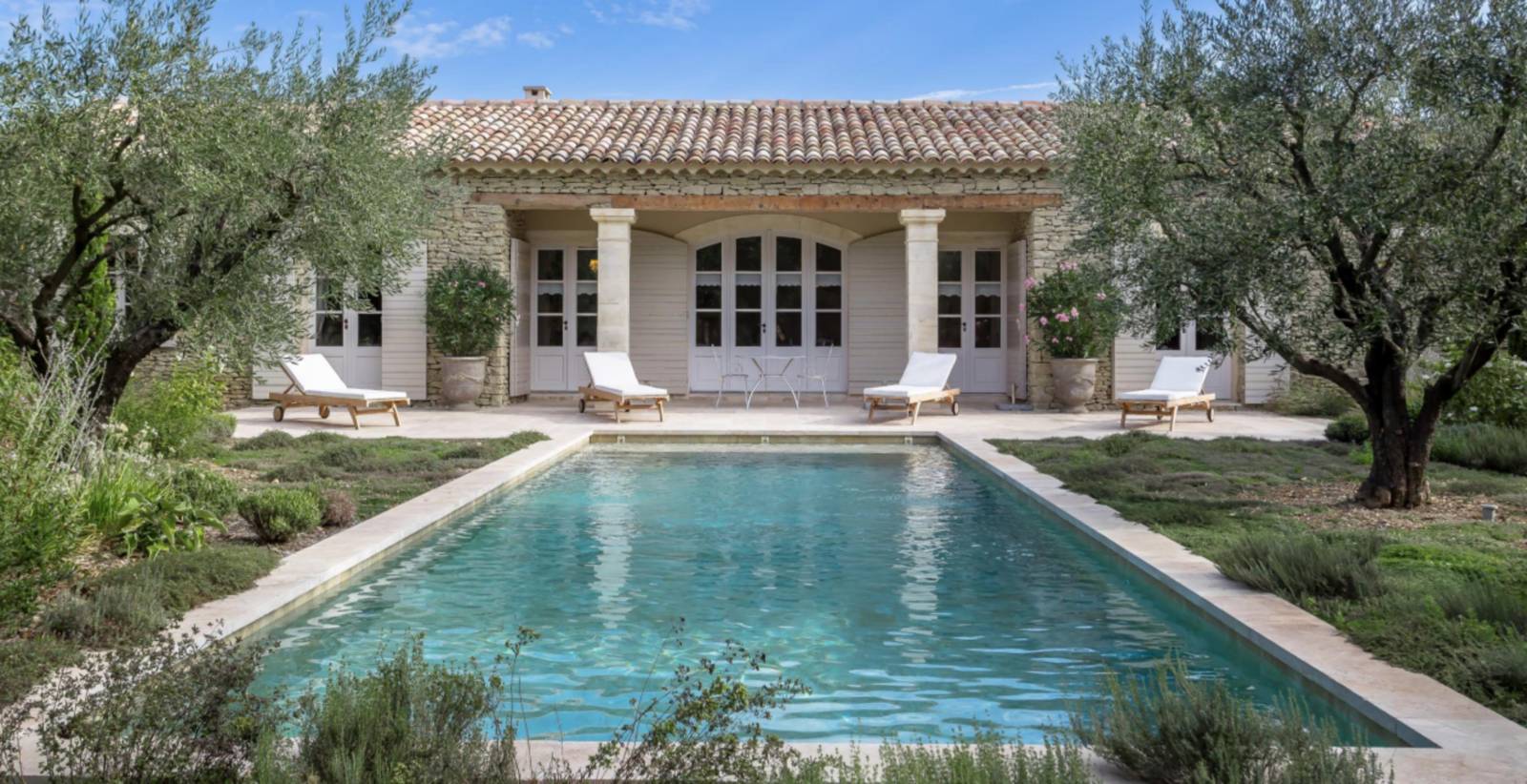 Charming architect-designed stone villa at the foot of Gordes with pool, expansive wooded garden, and high-end amenities.