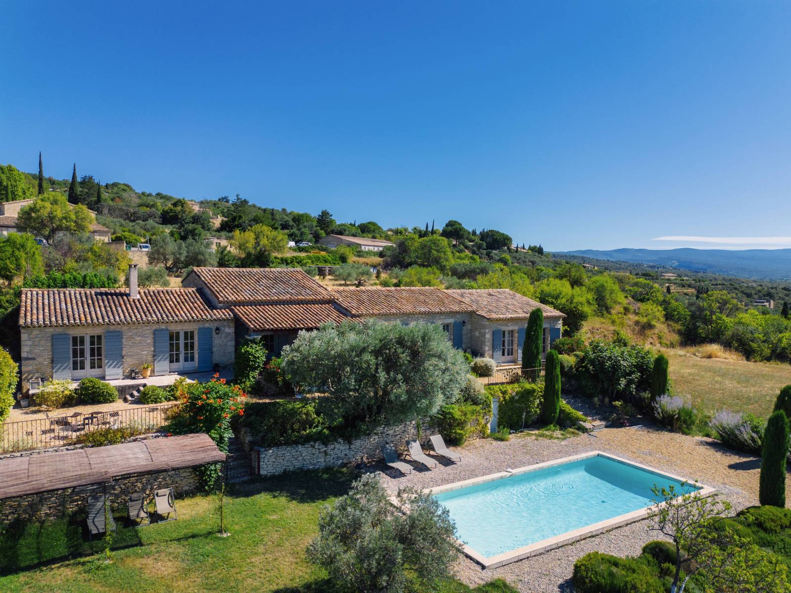 Location saisonnière d'une Maison de Famille Provençale en pierres avec piscine, face au Luberon et avec vue sur le village de Gordes.
