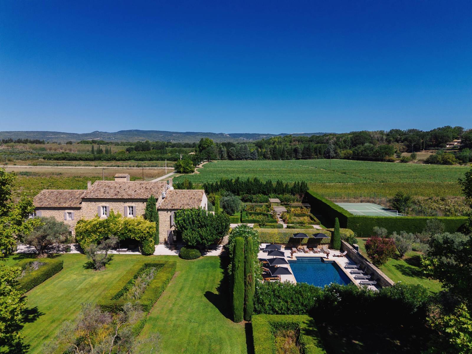 À louer au pied de Gordes, superbe Mas rénové dans un environnement très calme avec piscine, cuisine d’été et terrain de tennis.