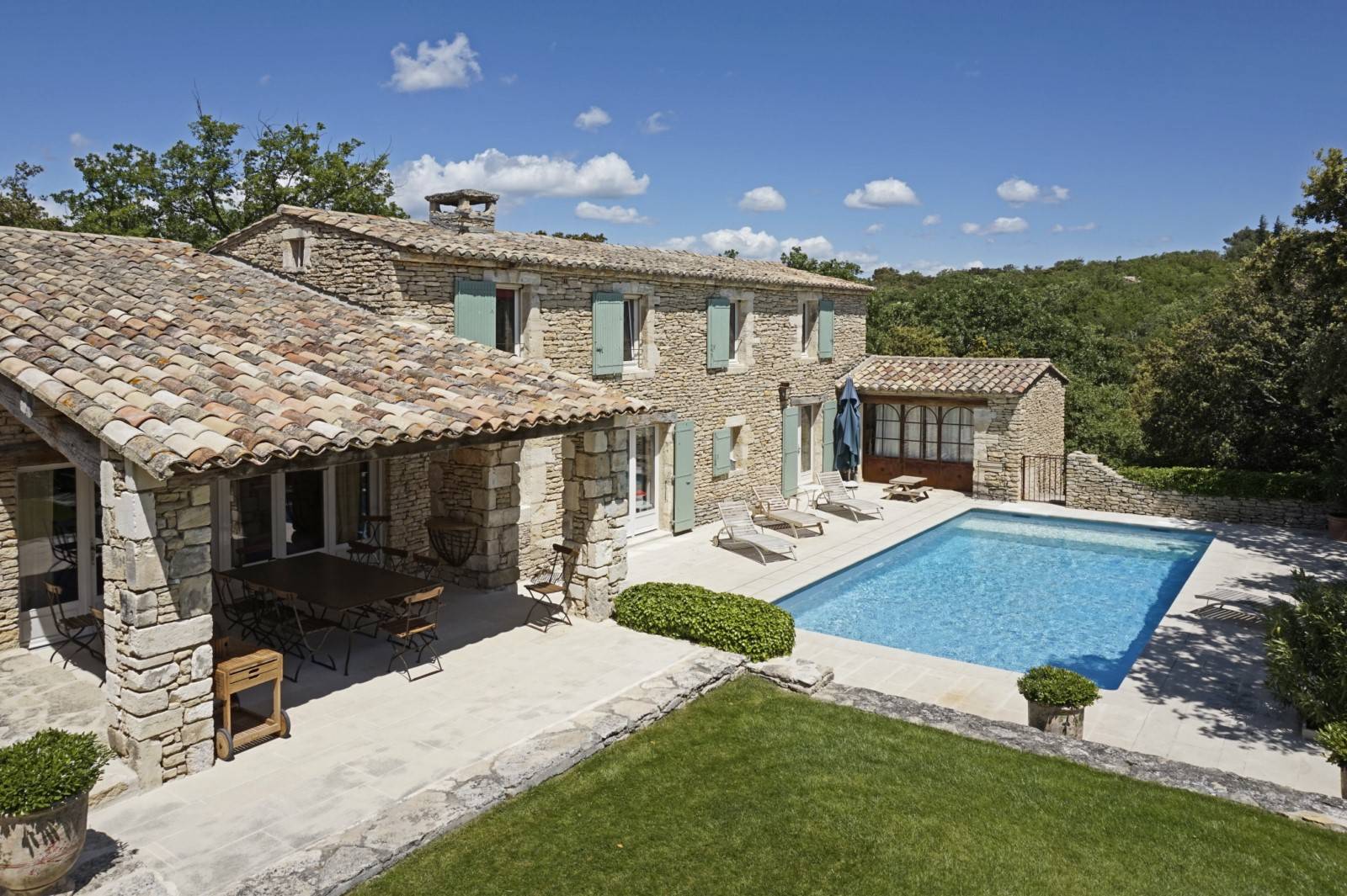 À louer à Gordes, élégante propriété en pierres avec piscine, tennis et terrain multisport, accessible à pied depuis le village.