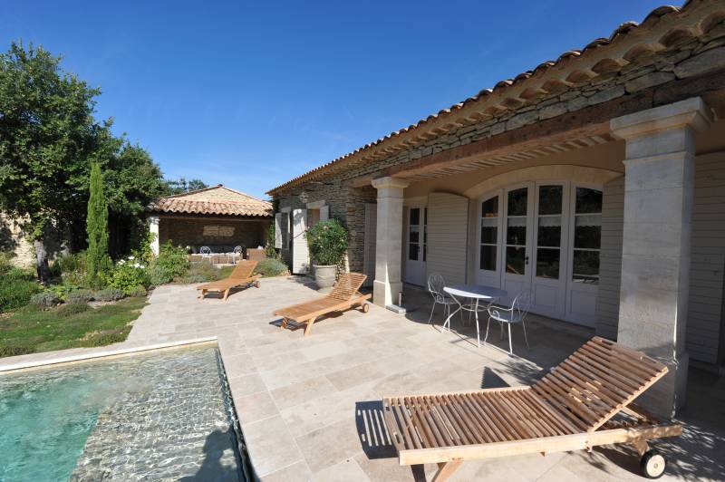 Villa d'architecte en pierres au pied de Gordes avec piscine, grand jardin boisé et prestations haut de gamme.