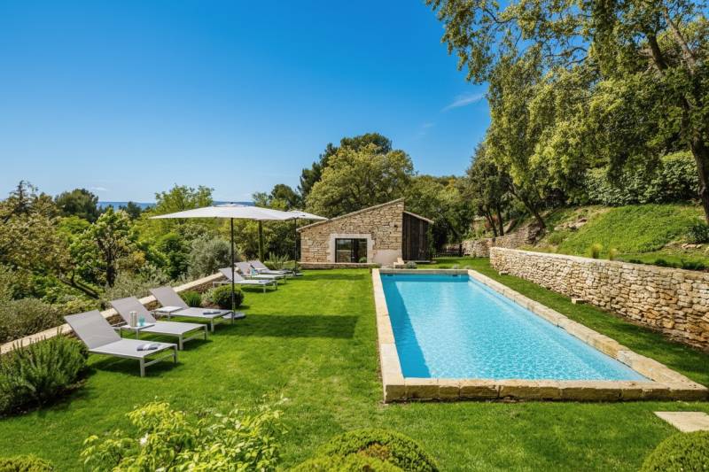 À louer à quelques minutes à pied du centre de Gordes maison en pierre de cinq chambres avec Bastidon, piscine et vue.